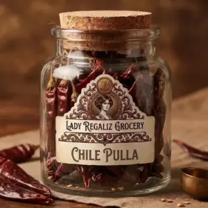 Chile pulla seco, delgado y de color rojo intenso en frasco de vidrio de época con tapón de corcho de Lady Regaliz Grocery.